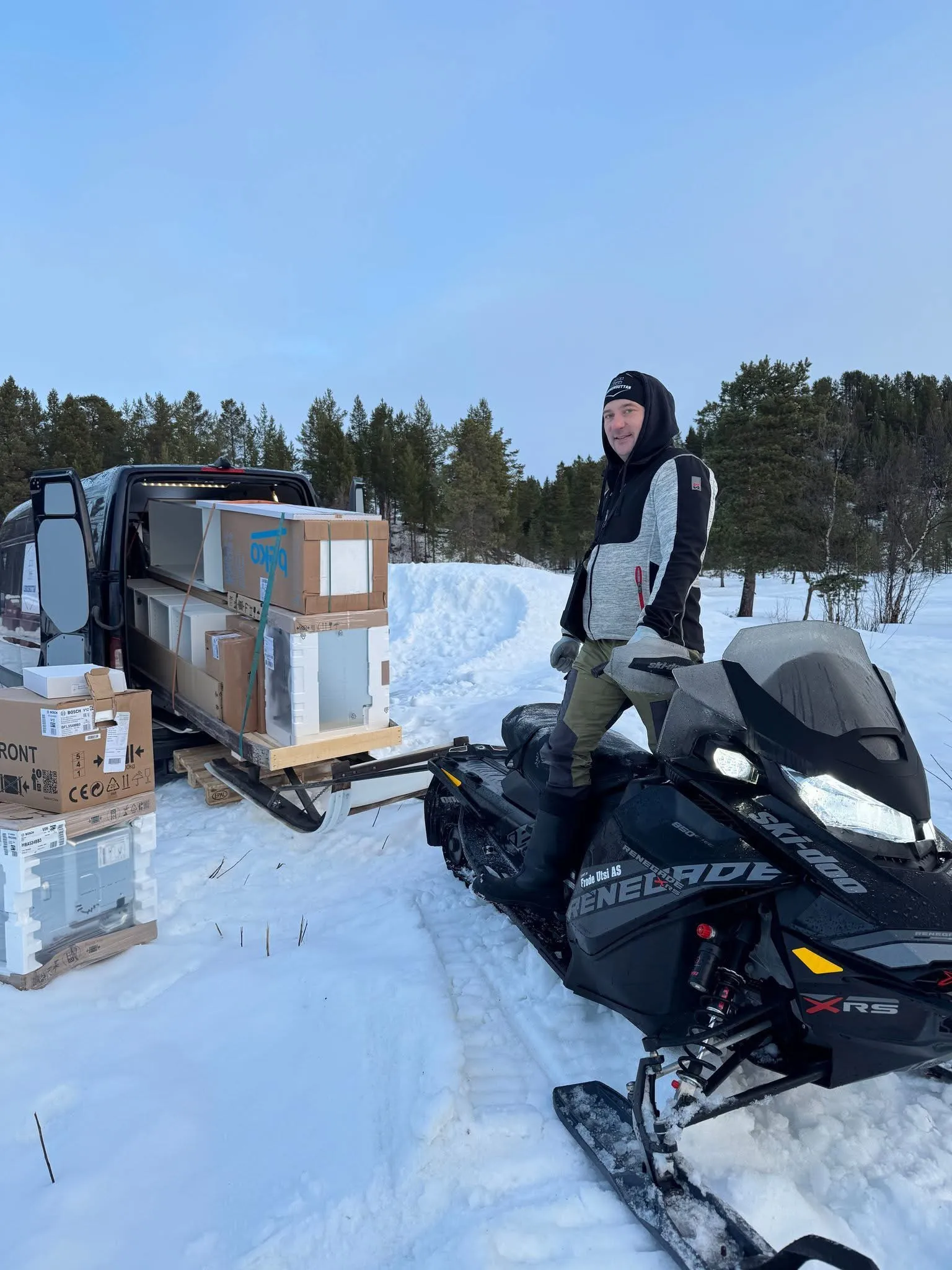 Niku med snøscooter og varebil lastet med kjøkkenskap og hvitevarer